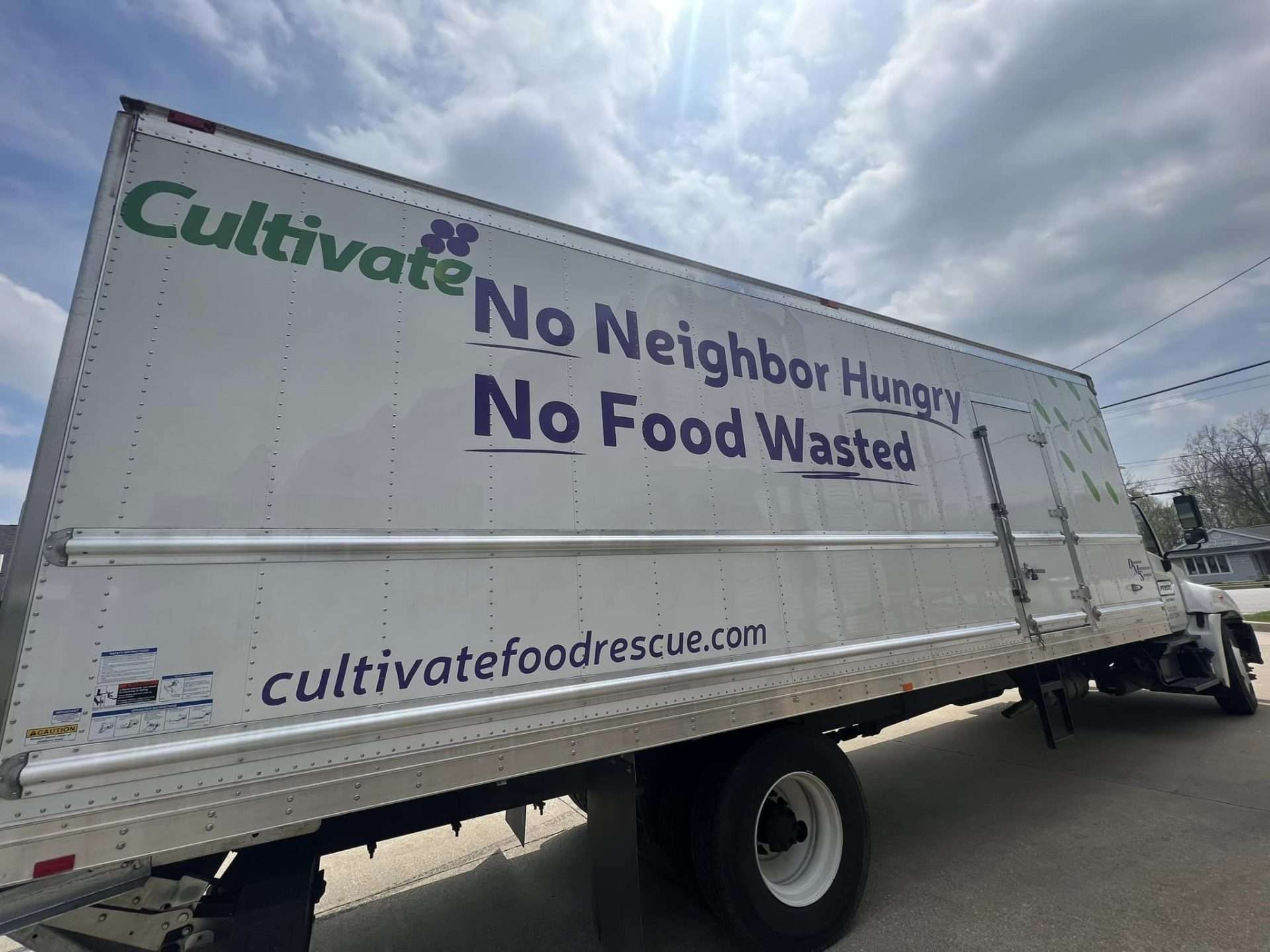 Side view photo of the Cultivate Food Rescue giant box truck with slogan "No Neighbor Hungry, No Food Wasted"